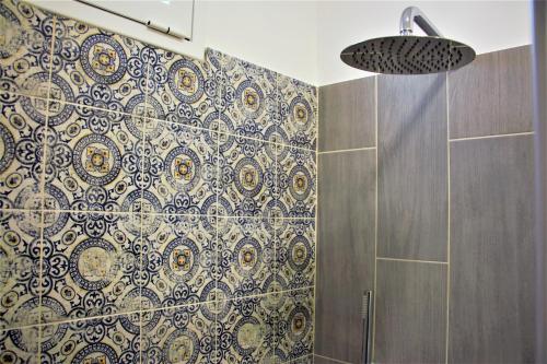 a bathroom with a shower with blue and white tiles at B&B Belvedere All'Idria in Ragusa