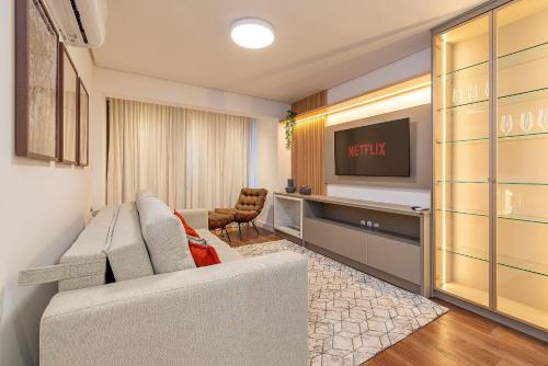 a living room with a couch and a tv at Dona Ella 202 - Apê NOVO no Centro de Gramado in Gramado