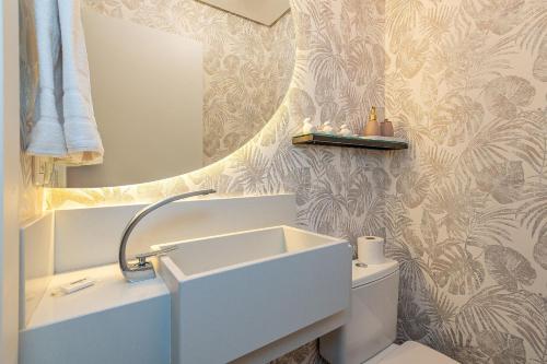 a bathroom with a sink and a mirror at Dona Ella 202 - Apê NOVO no Centro de Gramado in Gramado