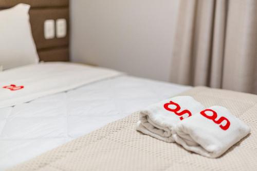 a white towel with the word end written on a bed at Dona Ella 202 - Apê NOVO no Centro de Gramado in Gramado