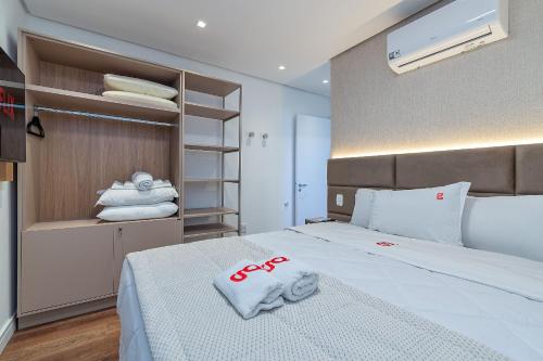 a bedroom with a bed with towels on it at Dona Ella 202 - Apê NOVO no Centro de Gramado in Gramado