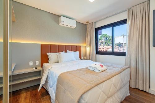 a hotel room with a bed and a window at Dona Ella 202 - Apê NOVO no Centro de Gramado in Gramado