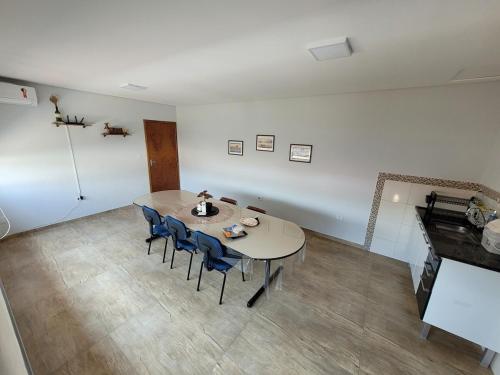 a dining room with a table and blue chairs at Edícula com estacionamento privativo, a uma quadra do Shopping Oriente - Casa da Sensei in São José dos Campos
