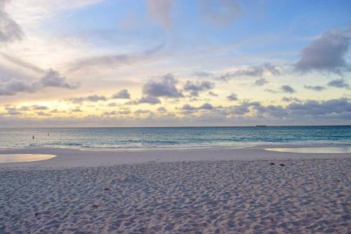 a beach with a cloudy sky and the ocean at Eagle Beach-Best value-Island View 1BR condo-R362 in Palm-Eagle Beach