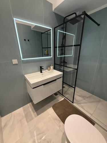 a bathroom with a sink and a mirror and a toilet at Kapnos - Classy and spacious place with a sea view in Kavála