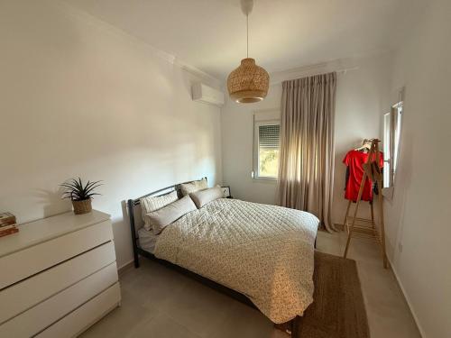 a bedroom with a bed and a dresser and a window at Kapnos - Classy and spacious place with a sea view in Kavála