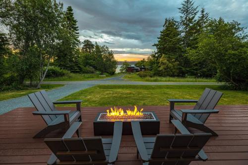 a patio with two chairs and a fire pit at Perch - Greenbank Cottage in Greenbank