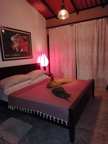 a bedroom with a bed with a cat laying on it at Mati Ambalama in Ambalangoda