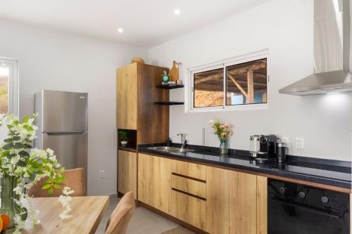 a kitchen with wooden cabinets and a stainless steel refrigerator at Casa Tortuga in Grote Berg