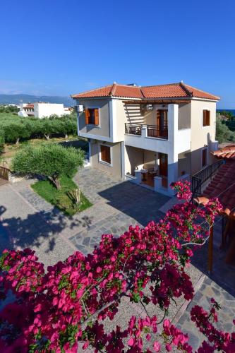 a house with pink flowers in front of it at So Nice Hotel in Marathokampos