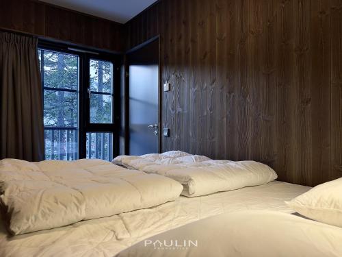 two twin beds in a room with a window at Lindvallen Ski Resort Pool and Padel - Sauna - 6 Guests in Sälen