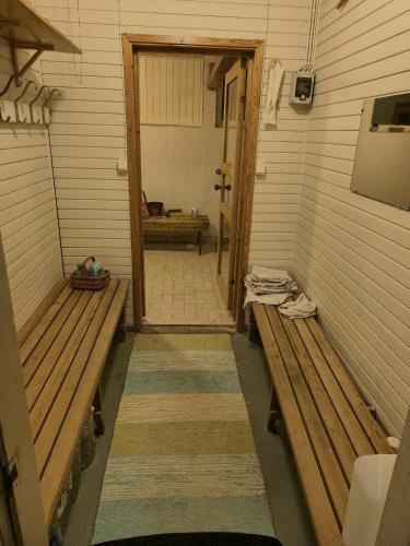 a room with two benches in a room with a door at Kaksio maaseudun rauhassa in Välijoki