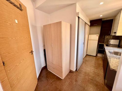 a kitchen with a sink and a wooden cabinet at MT Boutique Suites y Apartamentos - Adults Only - in Mataró