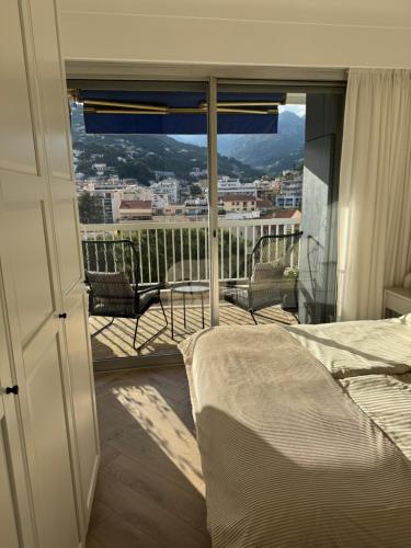 une chambre avec un lit et un balcon avec vue dans l'établissement L'Appartement Néréide - Côte d'Azur, à Roquebrune-Cap-Martin