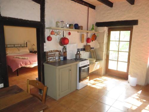 Il comprend une cuisine équipée d'une cuisinière et une chambre dotée d'un lit. dans l'établissement Iris Meadow Cottage, à Gardonne