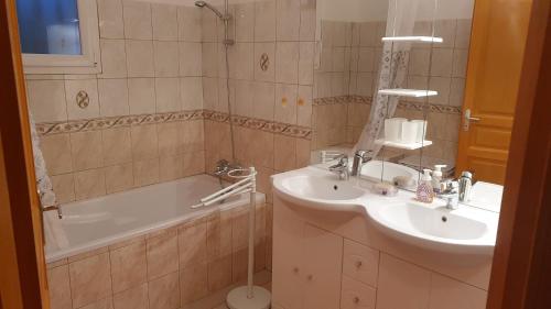une salle de bain avec un lavabo, une baignoire et un miroir dans l'établissement Villa PIETRAROSSA, à Lecci