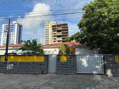 a retaining wall with a gate in front of a building at LumeHostel in João Pessoa