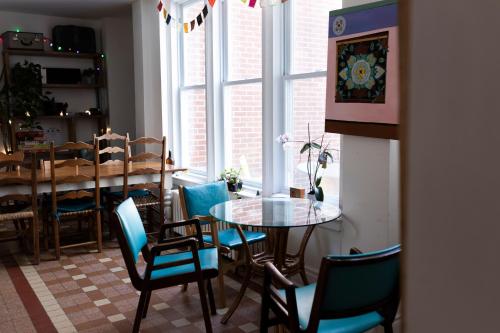 a dining room with a table and chairs and a window at Auberge de Jeunesse Magog-Orford Hostel in Magog-Orford