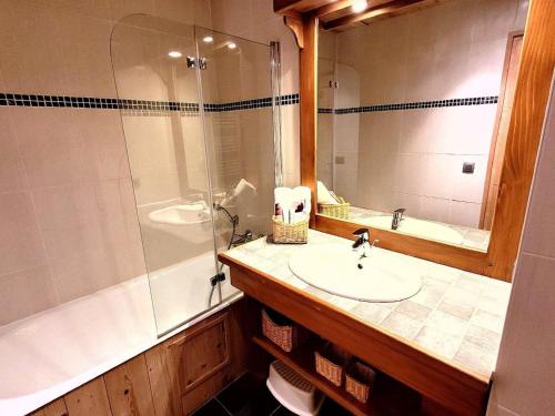 une salle de bain avec un lavabo, une baignoire et un miroir dans l'établissement Duplex lumineux avec terrasse et balcon, proche centre et pistes, parking, WiFi - FR-1-598-71, aux Gets