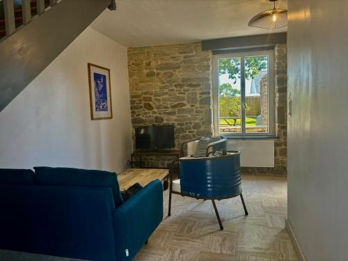 a living room with a blue couch and a table at Maisonnette bretonne typique Beg Meil Fouesnant Ty Breizh plage in Fouesnant