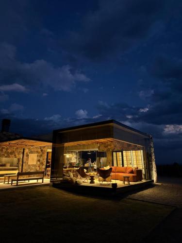 a building with a couch and chairs in it at night at Finca Boutique Un Buen Año in Tres Esquinas