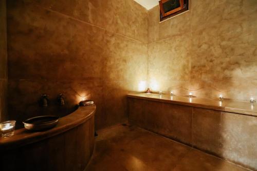 a bathroom with a tub with lights on the wall at Villa Sophia in Azib Oulad Lâdem