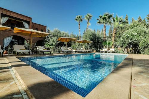 a swimming pool with chairs and umbrellas at a resort at Villa Sophia in Azib Oulad Lâdem