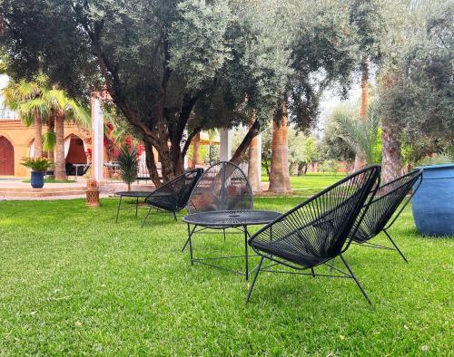 a group of chairs and tables sitting in the grass at Villa Sophia in Azib Oulad Lâdem
