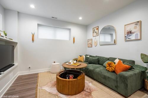 a living room with a green couch and a tv at Eco Stay by UChicago, Lakefront & Hyde Park! in Chicago