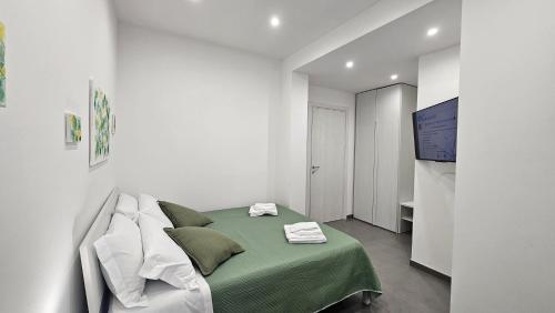 a white room with a green bed and a television at 41 Parallelo - Comfort rooms in Bari