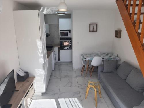 un salon avec un canapé et une table dans l'établissement Maison climatisée 2 chambres idéalement située Narbonne plage, à Narbonne-Plage