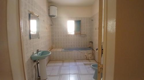 a bathroom with a tub and a sink and a toilet at Auberge Triskell in Nouakchott