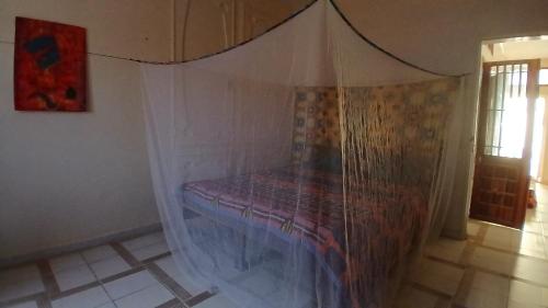 a bed in a room with a net at Auberge Triskell in Nouakchott