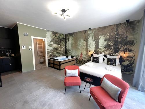 a bedroom with a bed and two red chairs at Heliconia in Bari