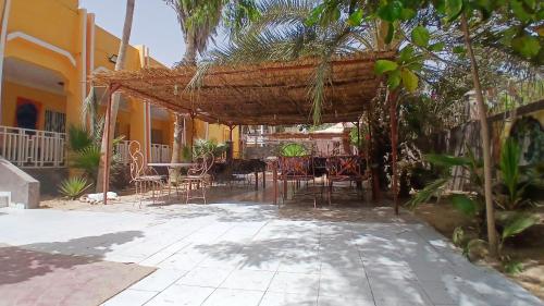 a patio with chairs and tables and a building at Auberge Triskell in Nouakchott