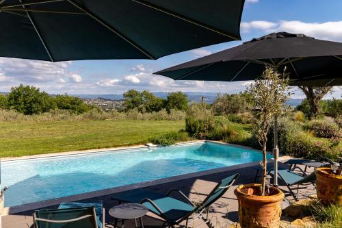 a swimming pool with chairs and an umbrella at Terre Luberon in Pertuis