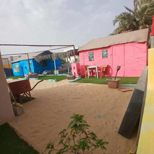 a pink house with a table in front of it at Auberge Triskell in Nouakchott
