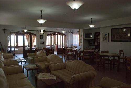 a living room with couches and chairs and a dining room at Asteri Hotel in Skala