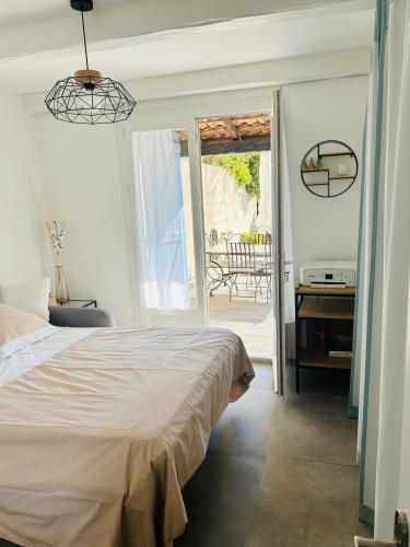 une chambre avec un lit et une porte ouverte sur un patio dans l'établissement Villa - Vue Mer et Tranquilité, à Carqueiranne