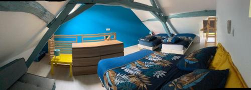 a room with two beds and a blue wall at Saumur Loire chambres et gite in Vernantes