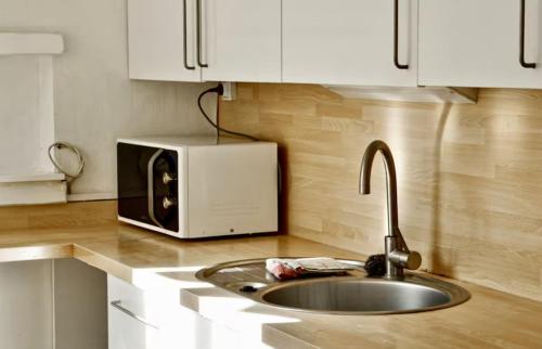 un comptoir de cuisine avec un évier et un micro-ondes dans l'établissement La ContrEscarpe - 4 couchages - Cour PRiVÉE - Secteur GARE CENTRE, à Amiens