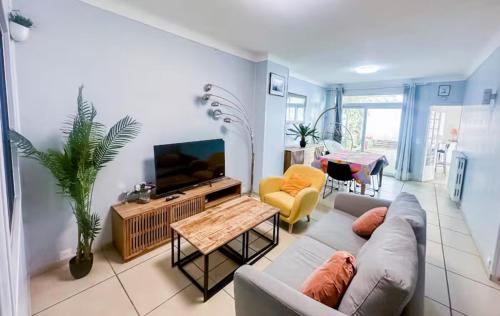 un salon avec un canapé et une télévision dans l'établissement La ContrEscarpe - 4 couchages - Cour PRiVÉE - Secteur GARE CENTRE, à Amiens