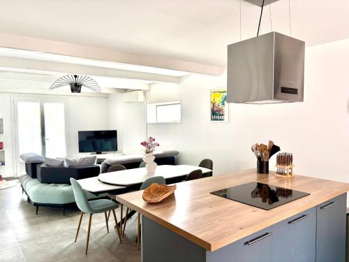 une cuisine et un salon avec une table et des chaises dans l'établissement Villa - Vue Mer et Tranquilité, à Carqueiranne
