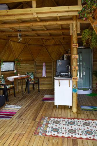 a living room with a tv on a wooden floor at Unique Glamping / Domo Betsaida in Guatapé