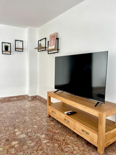 a flat screen tv sitting on top of a wooden entertainment center at El sitio de Ana in Burriana
