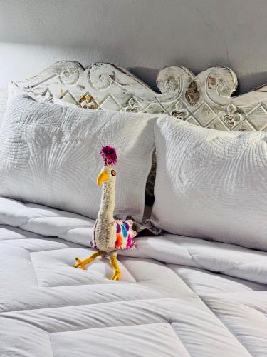 a toy chicken is sitting on a bed at Mini apartment in downtown SMA with Kitchenette and KING SIZE BED in San Miguel de Allende