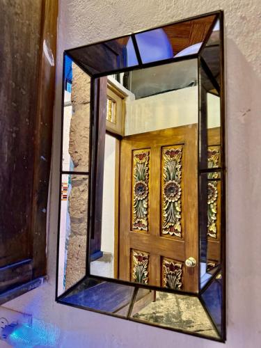 a mirror with a wooden door in a room at Mini apartment in downtown SMA with Kitchenette and KING SIZE BED in San Miguel de Allende
