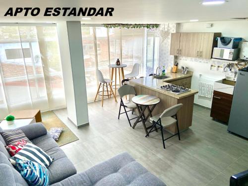 een woonkamer met een bank en een keuken bij Apartamentos View, calle del Malecón frente al lago in Guatapé