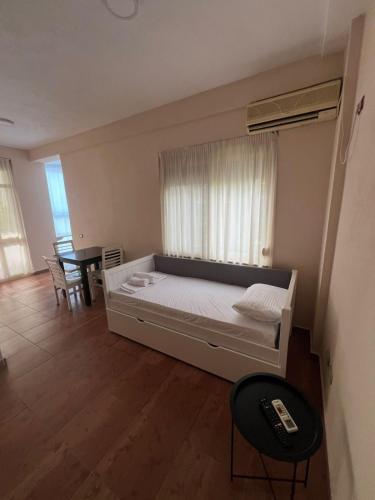 a bedroom with a bed with a window and a table at Blu Apart Hotel Durres in Durrës