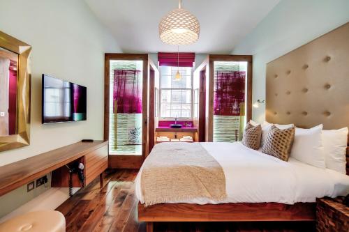 a bedroom with a large white bed and windows at Residences at The Gyle - London in London